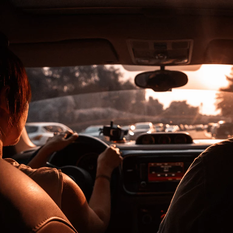 Couple travelling by car through the city at sunset